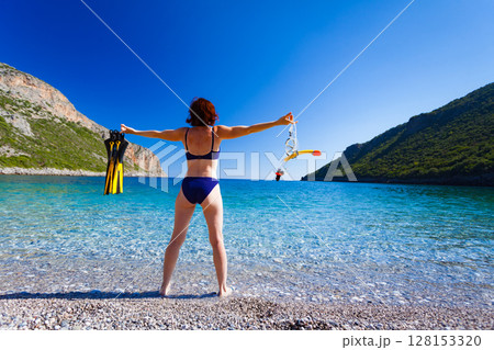 Woman with flippers snorkeling tube on beach Woman with flippers snorkeling tube on beach 128153320