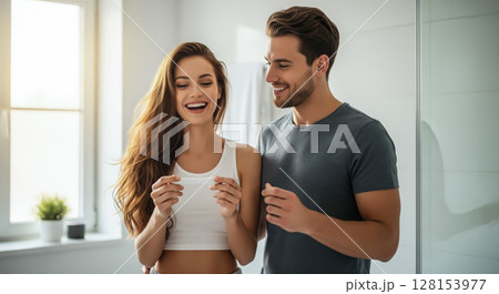 A couple looking at a pregnancy test together, sharing a joyful and emotional moment. The concept of partnership, new life, and the beginning of parenthood. Generative AI. 128153977