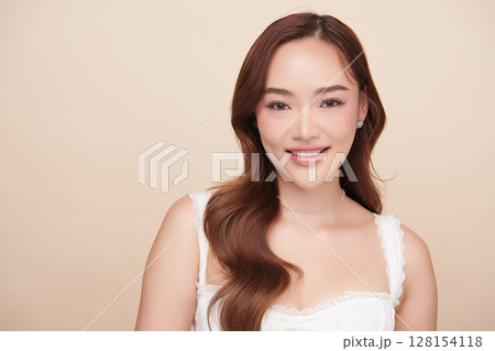 A beautiful young Asian woman with clean, fresh skin against a beige background. Skincare, facial treatment, cosmetology, beauty, and spa. An elegant portrait of an Asian woman. A beautiful young Asian woman with clean, fresh skin against a beige background. Skincare, facial treatment, cosmetology, beauty, and spa. An elegant portrait of an Asian woman. 128154118