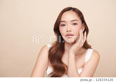 A beautiful young Asian woman with clean, fresh skin against a beige background. Skincare, facial treatment, cosmetology, beauty, and spa. An elegant portrait of an Asian woman. A beautiful young Asian woman with clean, fresh skin against a beige background. Skincare, facial treatment, cosmetology, beauty, and spa. An elegant portrait of an Asian woman. 128154120