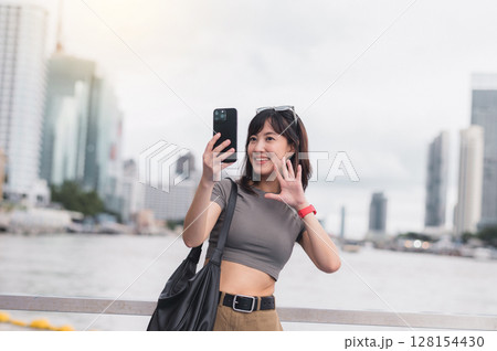 Happy solo southeast asian woman teenager blogger on world travel tourism in Bangkok Thailand express joy local cultural experience an explorer uses smartphone by boat on Chao Phraya river Asia Happy solo southeast asian woman teenager blogger on world travel tourism in Bangkok Thailand express joy local cultural experience an explorer uses smartphone by boat on Chao Phraya river Asia 128154430