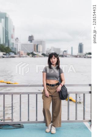 Solo Southeast Asian woman teenager blogger and world travel explorer. To wait and express calm over boat tourism concept. local cultural experience on Chao Phraya River Bangkok Thailand Asia Solo Southeast Asian woman teenager blogger and world travel explorer. To wait and express calm over boat tourism concept. local cultural experience on Chao Phraya River Bangkok Thailand Asia 128154431