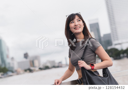 Solo Southeast Asian woman teenager blogger and world travel explorer wait to express joy on Chao Phraya River in Bangkok Thailand for boat local cultural experience and Asia tourism concept Solo Southeast Asian woman teenager blogger and world travel explorer wait to express joy on Chao Phraya River in Bangkok Thailand for boat local cultural experience and Asia tourism concept 128154432