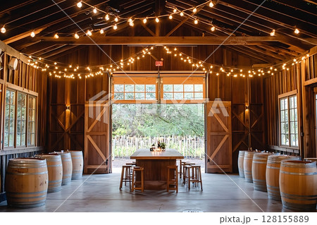 Rustic Barn Interior with Wine Barrels and String Lights Perfect for Wine Tasting or Event Venue. Rustic Barn Interior with Wine Barrels and String Lights Perfect for Wine Tasting or Event Venue. 128155889