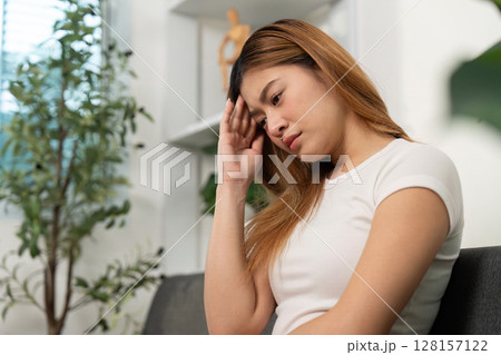 Mental Health. Young woman with a pensive expression, holding her head in thought. 128157122