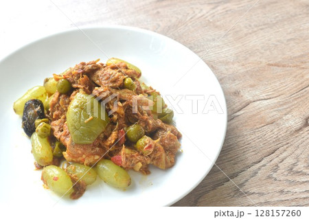 spicy fried roasted duck meat with grape and eggplant in curry on plate 128157260