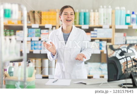 Friendly female pharmacist inviting customer to pharmacy Friendly female pharmacist inviting customer to pharmacy 128157645