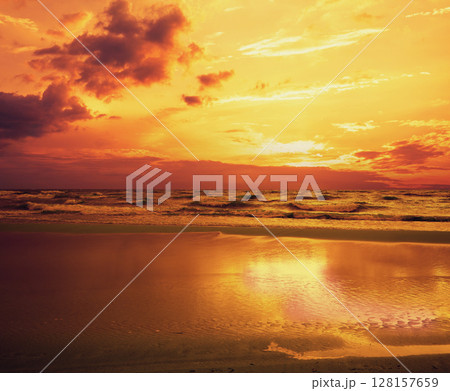 Early morning. Golden sunrise over the sea with a cloudy sky. Stormy weather Early morning. Golden sunrise over the sea with a cloudy sky. Stormy weather 128157659