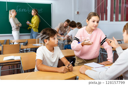 Fellow students having group work tasks during school class Fellow students having group work tasks during school class 128157799