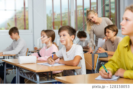 Schoolboy posing in classroom during lesson Schoolboy posing in classroom during lesson 128158053