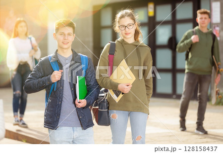 Smiling teenagers walking outside after lessons 128158437