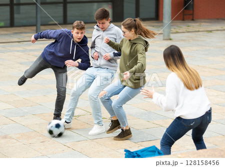Teenagers playing soccer with ball outside 128158456