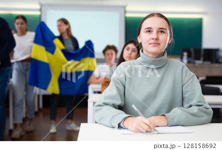 Teacher stands behind students with flag of Sweden Teacher stands behind students with flag of Sweden 128158692