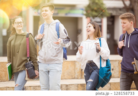 Carefree teen students walking outside school Carefree teen students walking outside school 128158733