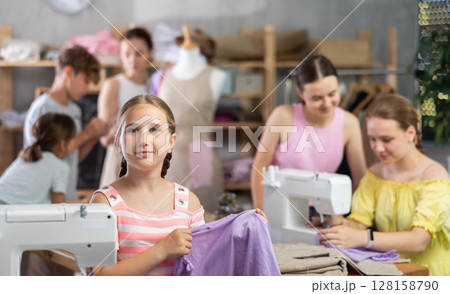 Smiling preteen schoolgirl in kids sewing workshop 128158790