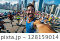 Marathon runner taking a dynamic selfie mid-run, with a bustling crowd of runners and the iconic city view behind him, emphasizing the thrill and achievement of participating in a major marathon event 128159014