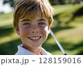 Happy caucasian boy at golfing training lesson, smiling at the camera on a sunny golf course, surrounded by lush green fairways and practicing his swing with enthusiasm, enjoying the sport and 128159016
