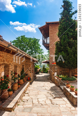 Peaceful monastery stone courtyard with flower pots in Meteora Greece Peaceful monastery stone courtyard with flower pots in Meteora Greece 128159693