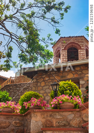 Monastery courtyard with potted flowers and bell tower in Meteora Greece Monastery courtyard with potted flowers and bell tower in Meteora Greece 128159698
