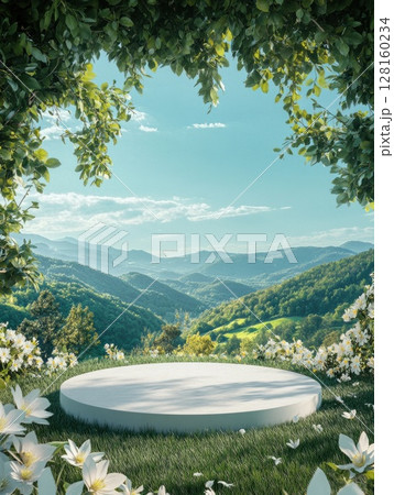 Smooth white round platform sits on lush green grass surrounded by white flowers framed by leafy branches overhead with scenic vista of rolling green hills and bright blue sky in background 128160234