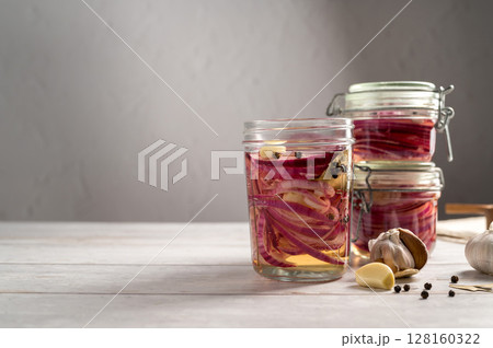 Cooking homemade pickled red onions in jars, bright background, copy space 128160322