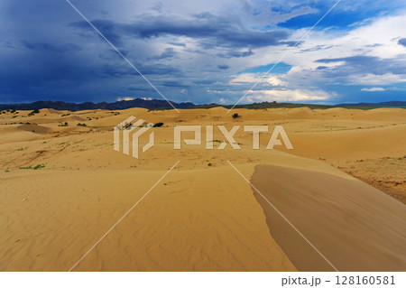Sand dunes with storm clouds at sunset Sand dunes with storm clouds at sunset 128160581