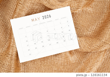 May 2026 calendar card on golden color textile background. May 2026 calendar card on golden color textile background. 128161134