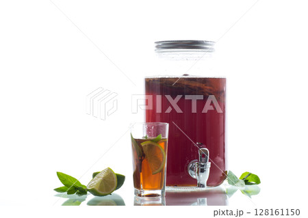 Refreshing kombucha in a glass jar and a glass with lime on white background Refreshing kombucha in a glass jar and a glass with lime on white background 128161150