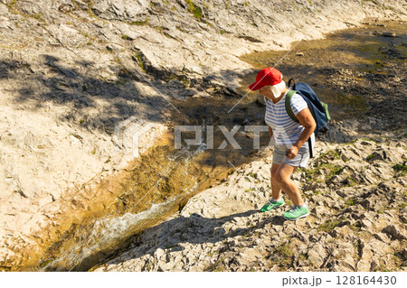 Senior Woman Hiking Near Rocky Mountain Stream 128164430