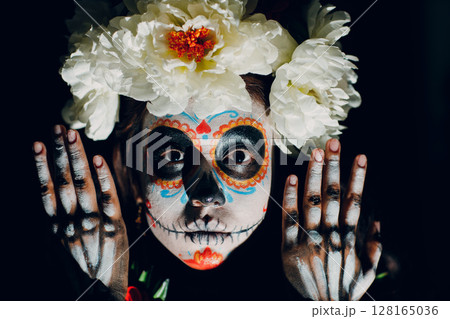 Woman with mexican skull halloween makeup on face. Day of the dead aka Dia de los Muertos and halloween concept. 128165036