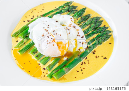 White Plate of Asparagus Nestled in Hollandaise Sauce With Poached Egg 128165176