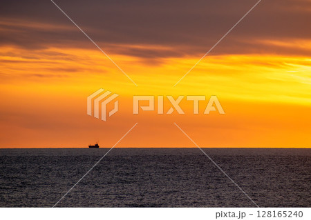 美しい夕暮れの海に浮かぶ貨物船 128165240