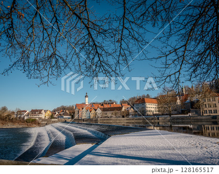 Historic Town Of Landsberg Am Lech In Bavaria: Winter Charm With A Frozen River And Colorful Houses Under A Clear Blue Sky 128165517
