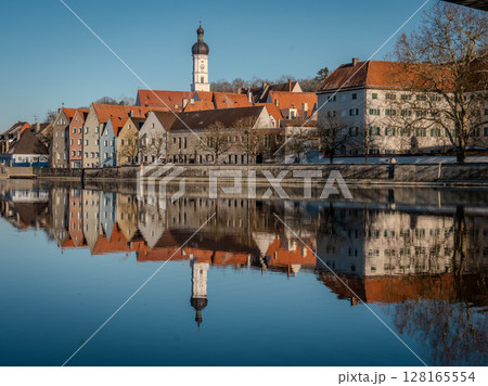 Historic Town Of Landsberg Am Lech In Bavaria: Winter Charm With A Frozen River And Colorful Houses Under A Clear Blue Sky Historic Town Of Landsberg Am Lech In Bavaria: Winter Charm With A Frozen River And Colorful Houses Under A Clear Blue Sky 128165554