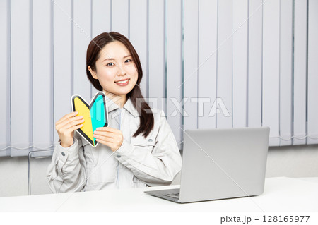 初心者マークを持つ作業服の女性01 128165977
