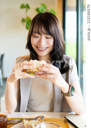 カフェでランチを食べる笑顔の女性 128166876