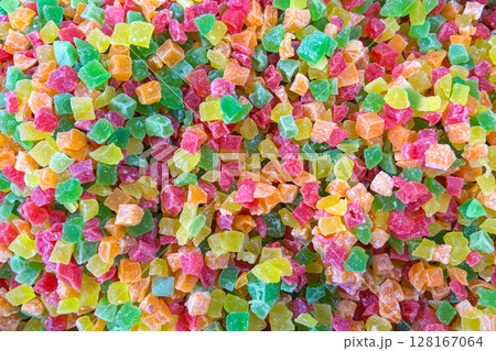 A colorful assortment of small, cubed candied fruits in vibrant shades of green, red, yellow, and orange A colorful assortment of small, cubed candied fruits in vibrant shades of green, red, yellow, and orange 128167064