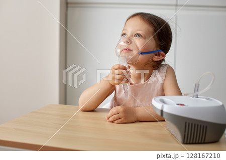 cute little toddler girl inhaling medicine on nebulizer and holding it on her own cute little toddler girl inhaling medicine on nebulizer and holding it on her own 128167210