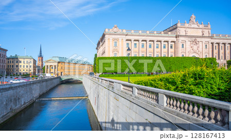 The Parliament House alongside its waterway shines under a clear blue sky on a bright day in Stockholm, Sweden. 128167413