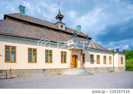 Skogaholm Manor stands proudly under a bright blue sky, showcasing its traditional Swedish architecture and the tranquility of Skansens open-air museum in Stockholm during summer. Sweden Skogaholm Manor stands proudly under a bright blue sky, showcasing its traditional Swedish architecture and the tranquility of Skansens open-air museum in Stockholm during summer. Sweden 128167416