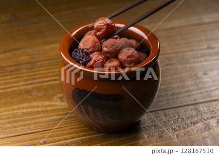 箸で持ち上げられた壺入りの梅干し 128167510