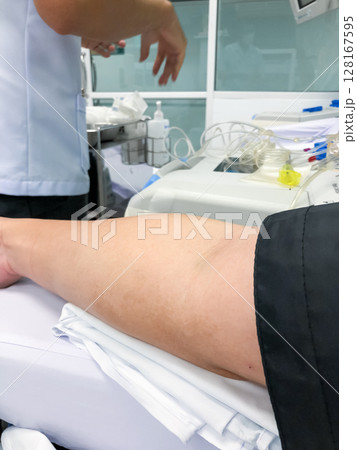 Blood platelet donation, a male nurse inserts a needle into donors arm to draw blood at a hospital. 128167595