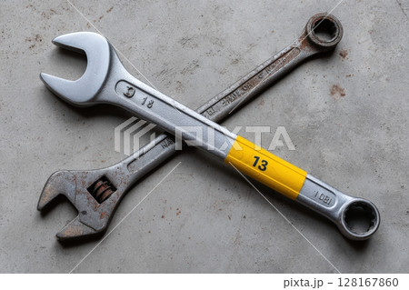 Wrenches laid on concrete surface indicating tools used for repair and maintenance tasks 128167860