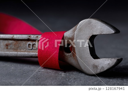 Wrench wrapped in red fabric on a gray surface during a workshop setting 128167941