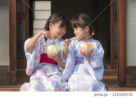縁側でかき氷を食べる浴衣姿の姉妹 縁側でかき氷を食べる浴衣姿の姉妹 128168510
