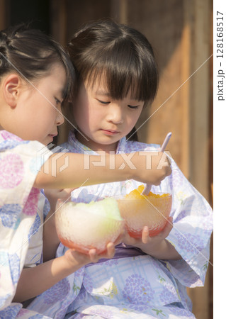 縁側でかき氷を食べる浴衣姿の姉妹 縁側でかき氷を食べる浴衣姿の姉妹 128168517