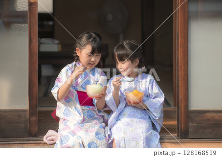 縁側でかき氷を食べる浴衣姿の姉妹 縁側でかき氷を食べる浴衣姿の姉妹 128168519