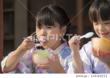 縁側でかき氷を食べる浴衣姿の姉妹 128168521