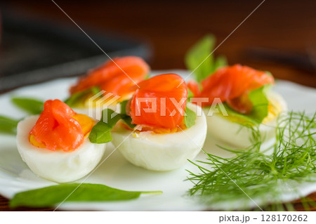 Decorated eggs with red fish and herbs on the table 128170262