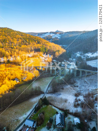 The railway stone bridge in Novina, Krystofovo udoli stands majestically against the backdrop of Jested Mountain during a colorful winter sunset, illuminating the surrounding landscape. The railway stone bridge in Novina, Krystofovo udoli stands majestically against the backdrop of Jested Mountain during a colorful winter sunset, illuminating the surrounding landscape. 128170421